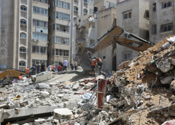 Image of rubble of destroyed buildings and people examining the damage