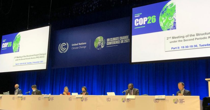 Image from COP26, with panellists seated across a table